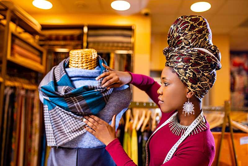 African saleswoman in storage update cotton and lace fabric showroom