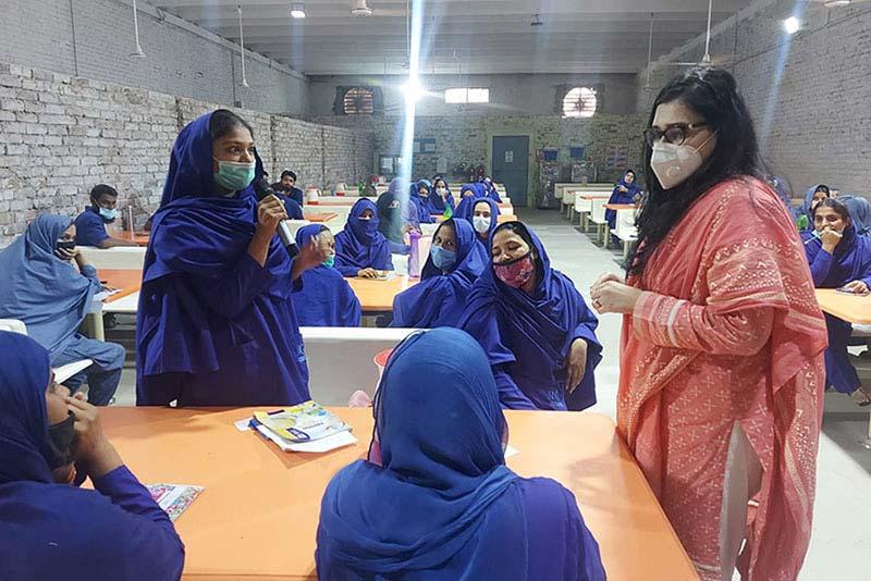 Des ouvrières du textile discutent avec Gulalai Khan de leur expérience lors de sessions de formation.