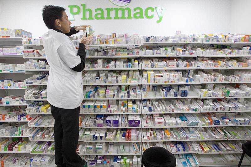 Remplir des ordonnances pour des clients dans une pharmacie à Nairobi, au Kenya.