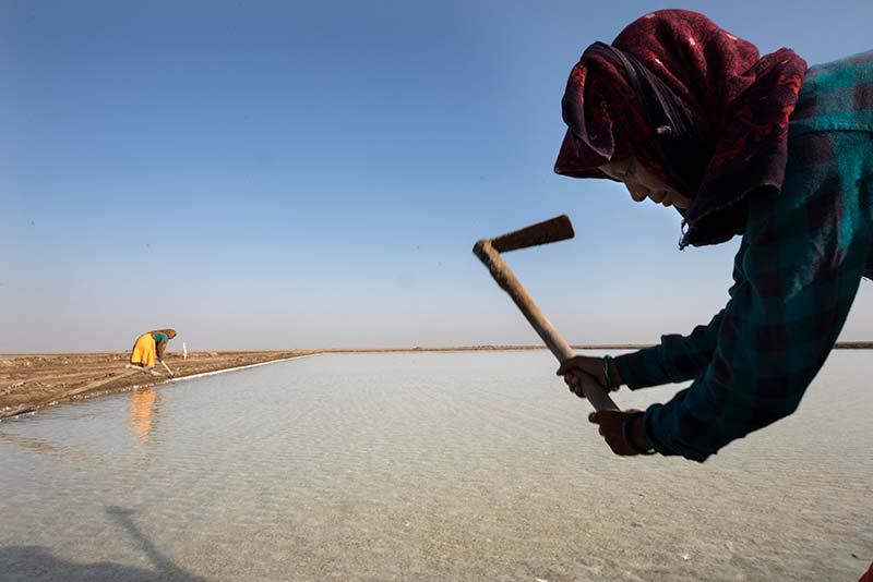 Komalben Rajnik Rapucha, (right) and Hansaben Rameshbhai Dodivadiya (left), salt pan workers, maintain and repair the banks of salt pans in Little Rann Off Kutch, India.