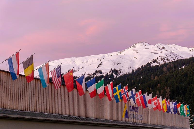 Coucher de soleil sur le Centre de congrès de Davos, paré de drapeaux, pendant le Forum économique mondial