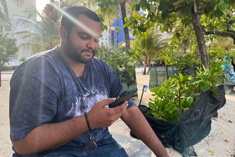 Mohammad Yaeesh consulte son téléphone mobile à l'Artificial Beach de Malé.